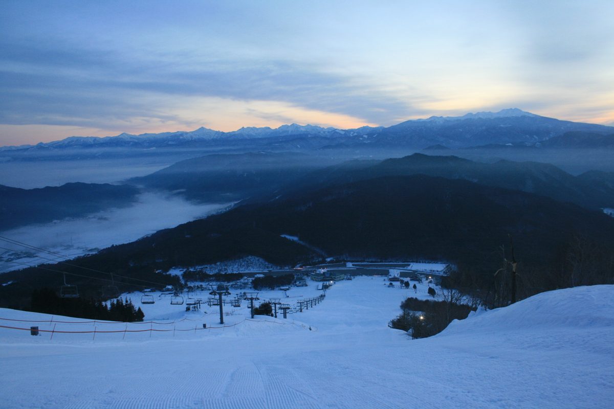 Snowy Hida Mountains seen across a sea of clouds from a mountain slope