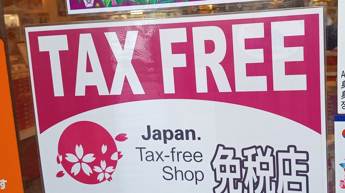 A pink and white Japan Tax-free Shop sign on a shop door