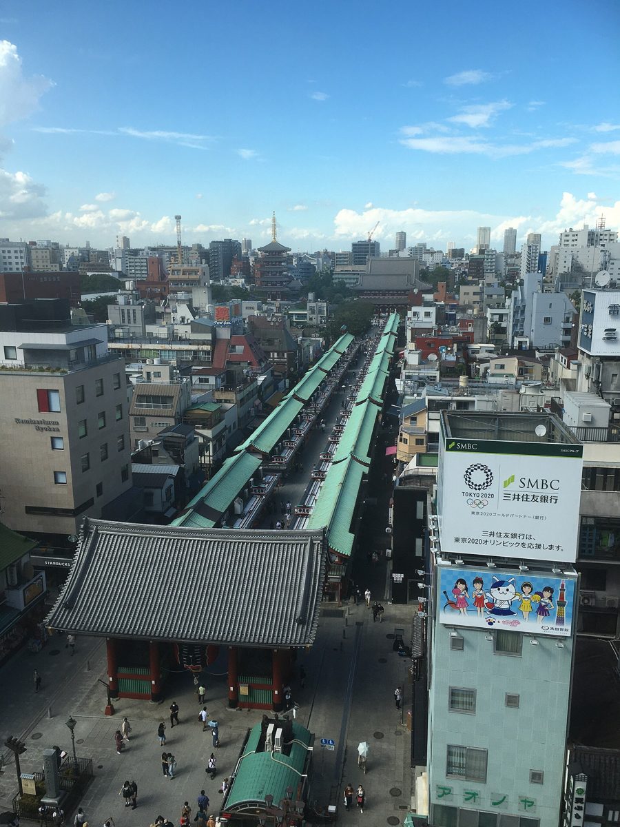 The tiled roof of Kaminarimon seen from above, with a long covered shopping street running behind it