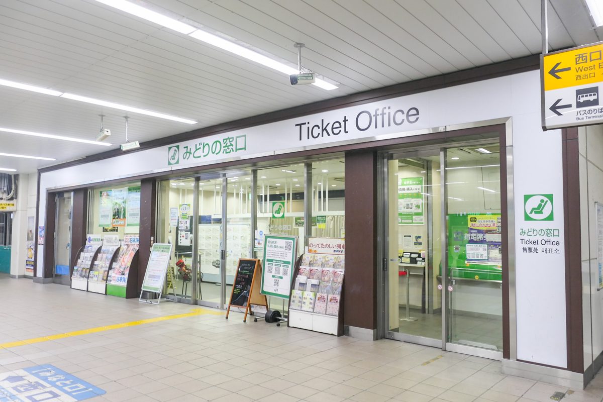 Front of a JR ticket office with a Ticket Office sign and glass doors inside a station