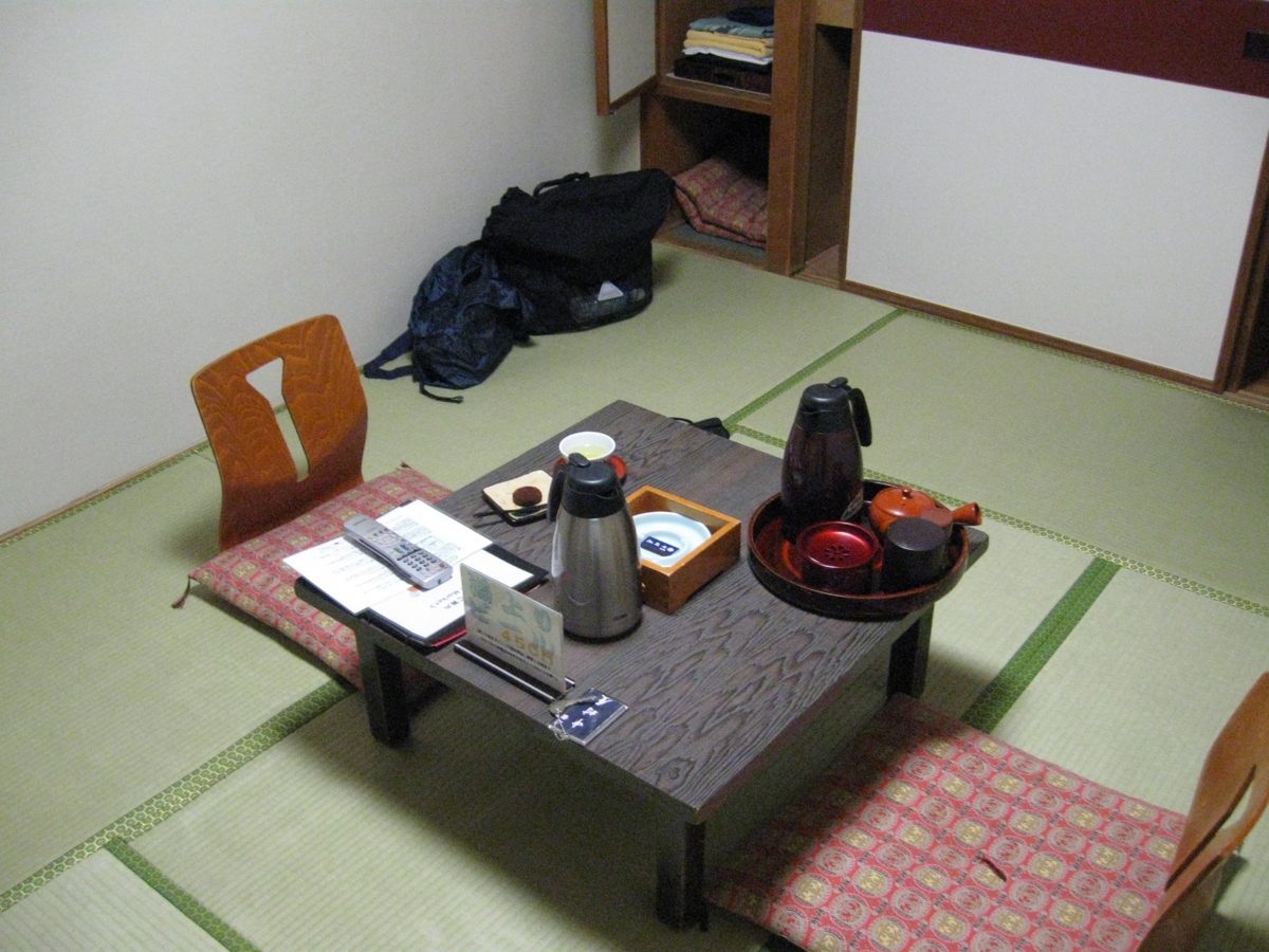 A tatami guest room with a low table and floor cushions