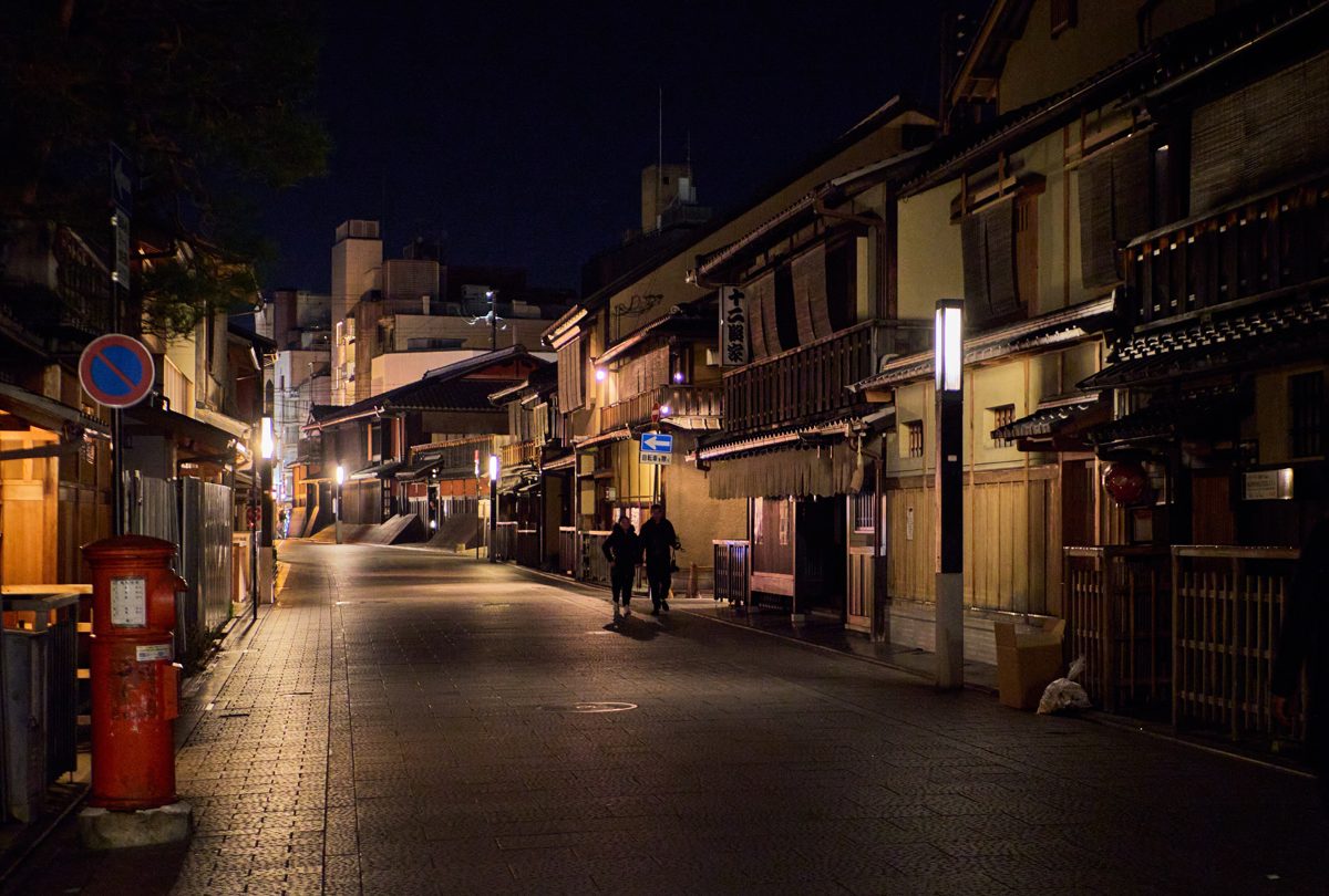 A quiet street lined with wooden townhouses in Gion, Kyoto, at night
