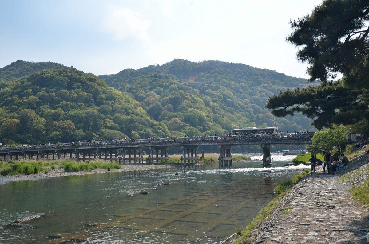 Togetsukyo Bridge crossing the river below green hills in Arashiyama