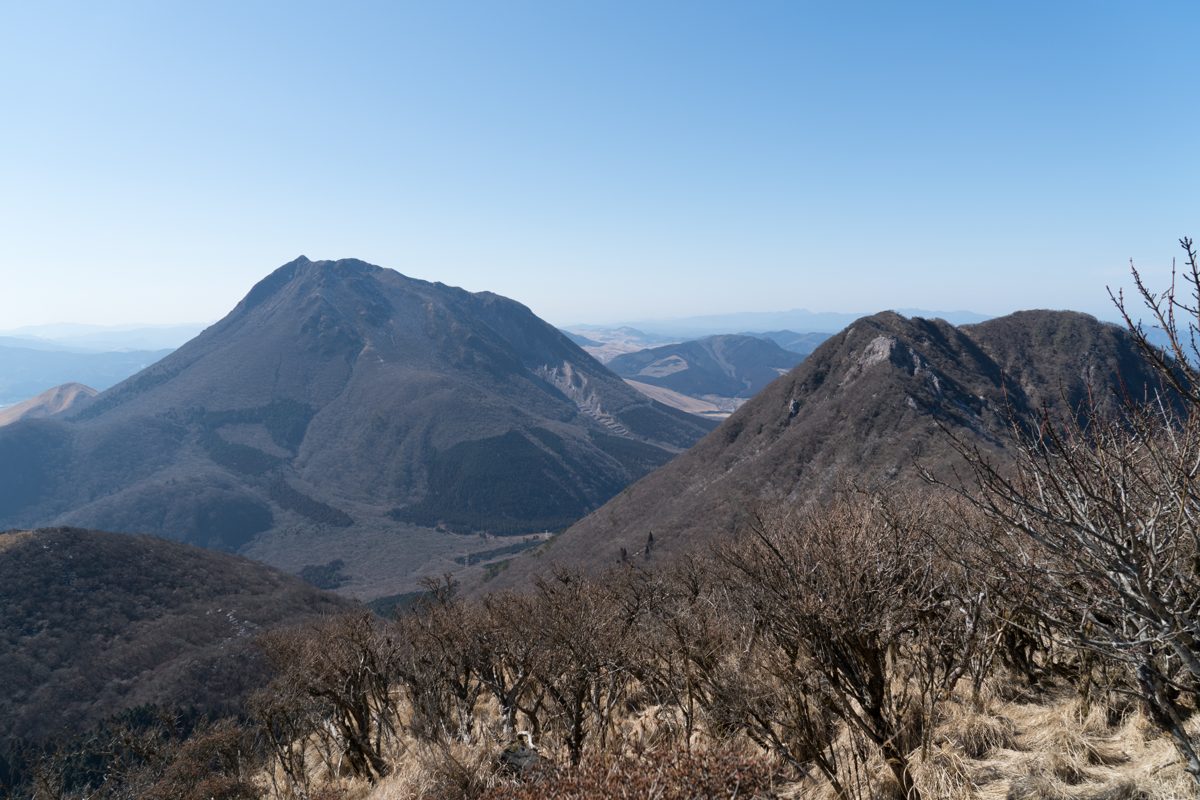 Mount Yufu rising above wooded hills under a clear blue sky
