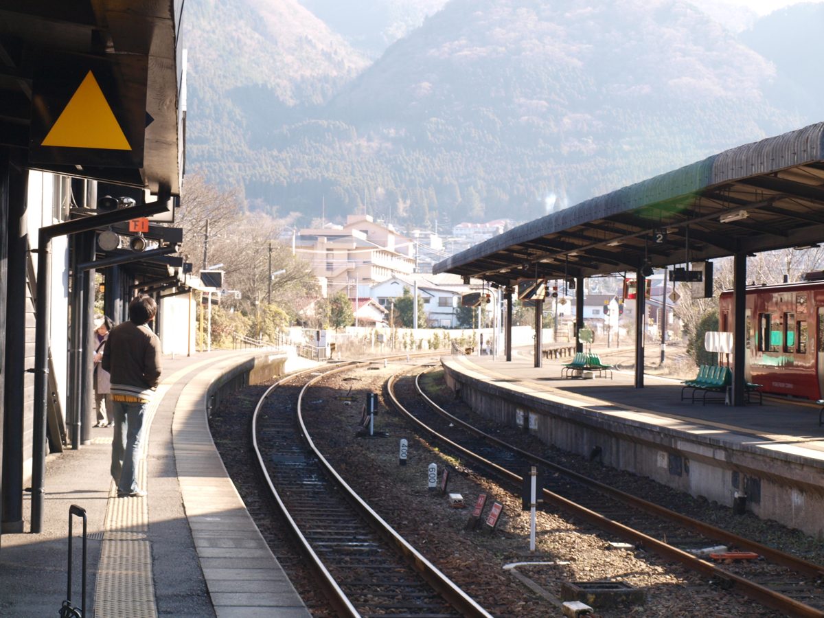 Tracks and platforms at Yufuin Station with mountains behind