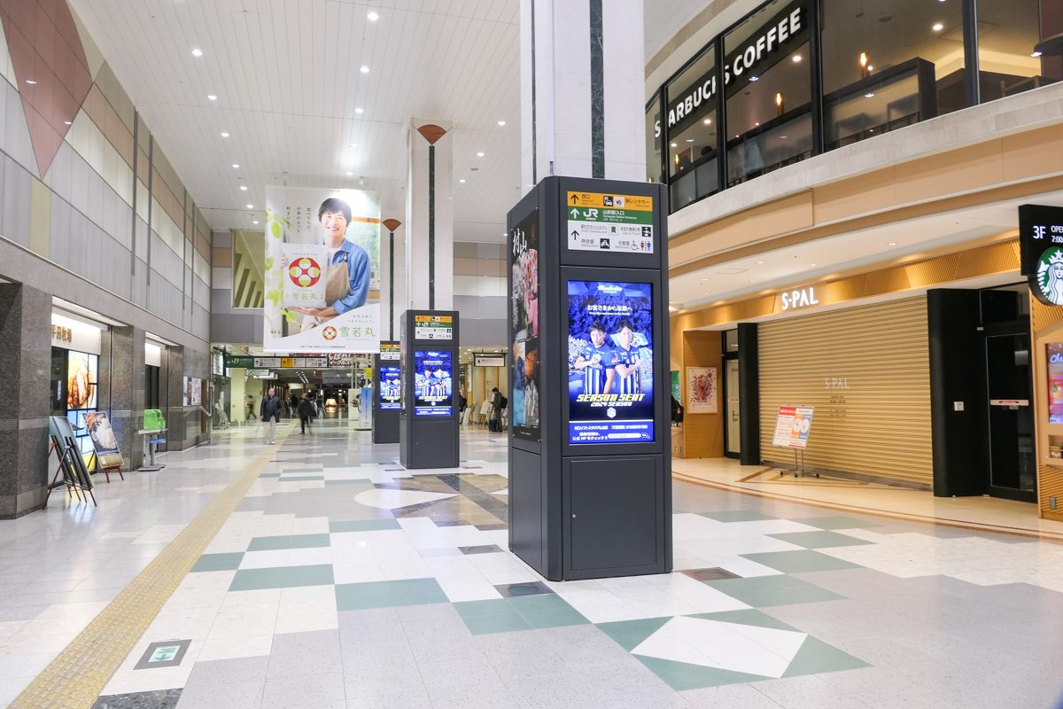 The concourse of JR Yamagata Station with shops and digital signs